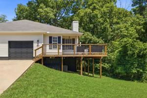 a house with a deck on a lawn at Bed n Bikefast in Bentonville