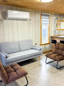 a living room with a couch and a piano at Cabañas Costanera Puyuhuapi in Puerto Puyuhuapi +3 photos