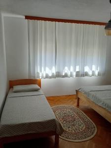 a bedroom with two twin beds and a window at Casa SOLE in Bihać