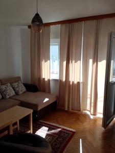 a living room with a couch and a window at Casa SOLE in Bihać