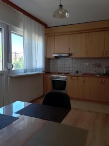 a kitchen with wooden cabinets and a table and a window at Casa SOLE in Bihać +7 photos