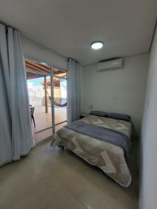 a bedroom with a bed and a sliding glass door at Casa Brisa - Las Caracolas in Rio Grande
