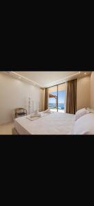 a bedroom with two beds with a view of the ocean at Panorama Villa Infinity Pool in Shëngjin +79 photos