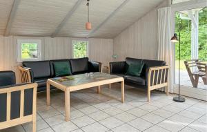 a living room with a couch and a table at Holiday Home Blåbærvangen V in Oxbøl