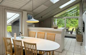 a kitchen and dining room with a table and chairs at Holiday Home Blåbærvangen V in Oxbøl