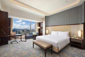 a bedroom with a bed and a desk and a computer at Shangri-La Jinan in Jinan