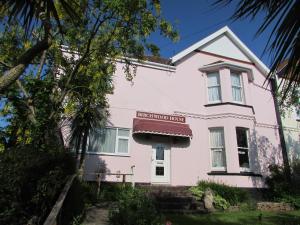 a pink house with a sign on the side of it at Birchwood House in Paignton