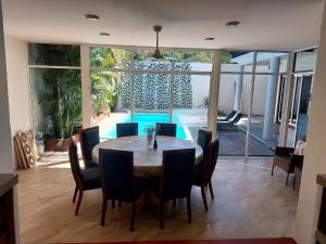 a dining room with a table and chairs and a pool at Huatulco house near beach with pool in Tangolunda