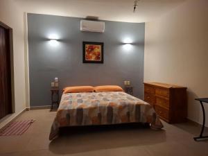a bedroom with a bed and a wooden dresser at Huatulco house near beach with pool in Tangolunda