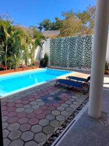 a swimming pool with a bench next to a house at Huatulco house near beach with pool in Tangolunda +25 photos