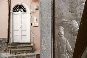 a door with a mural of people on the wall at Corsaro Etna Palace in Motta SantʼAnastasia