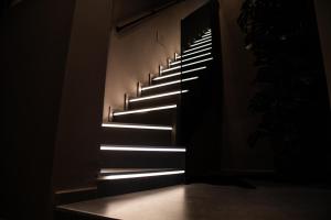 a staircase in a dark room with lights on it at Corsaro Etna Palace in Motta SantʼAnastasia