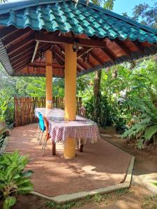 a table and chairs under a pavilion on a patio at B & B CHARM in Dickwella