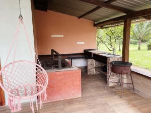 a porch with a swinging chair and a piano at Guanawanna in Loreto