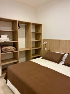 a bedroom with a large bed and shelves at Plaza Suites Cafayate in Cafayate +2 photos