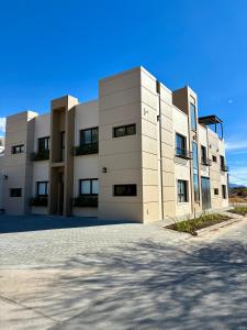 a large white building with a driveway in front of it at Plaza Suites Cafayate in Cafayate