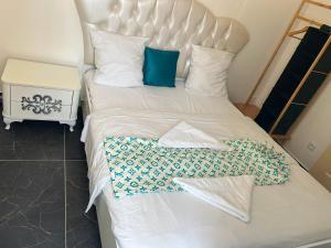 a large white bed with blue and white pillows at Résidence les Jardins Secret in Romilly-sur-Seine
