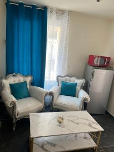a living room with two chairs and a coffee table at Résidence les Jardins Secret in Romilly-sur-Seine