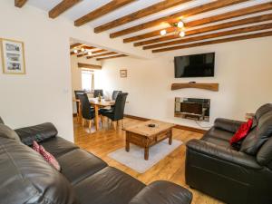 a living room with a couch and a table at Beudy Bach in Abergele