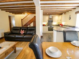 a living room with a couch and a table at Beudy Bach in Abergele