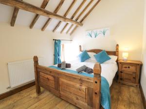 a bedroom with a wooden bed and a window at Beudy Bach in Abergele