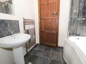 a bathroom with a sink and a tub and a toilet at Beudy Bach in Abergele +18 photos