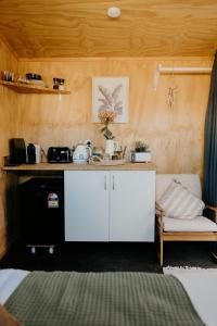 a kitchen with a white counter and a couch in a room at Warm & Cosy Studio Cabin in Hamilton