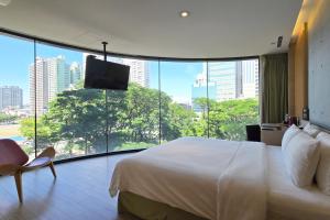 a bedroom with a large bed and a large window at Hotel R14 in Kaohsiung