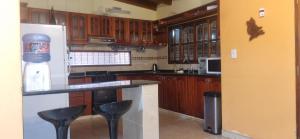 a kitchen with wooden cabinets and a counter with stools at Cata, Casa de Descanso in Salta