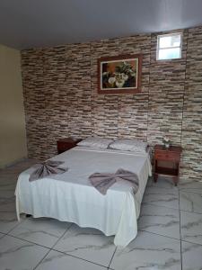 a bedroom with a bed and a brick wall at Anthony in Salinópolis