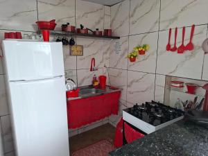 a small kitchen with a white refrigerator and a stove at Anthony in Salinópolis +10 photos