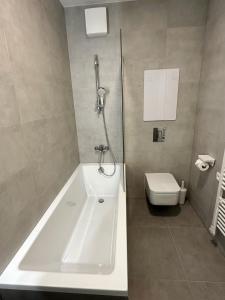 a bathroom with a bath tub and a toilet at Sitka1 apartment in Trenčín