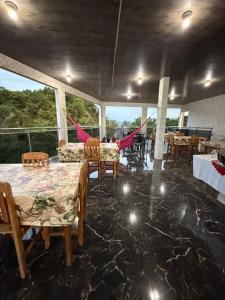a dining room with tables and chairs and a large window at Caribe de Alter - Hotel & Pousada in Santarém