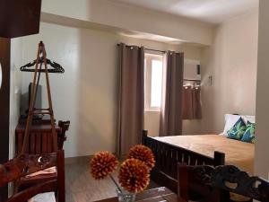 a bedroom with a bed and a table with flowers at Sweet Escape Executive Studio at One Regis in Bacolod