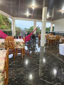 a dining room with tables and chairs in a room at Caribe de Alter - Hotel & Pousada in Santarém