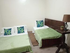 a room with two beds and a table with a lamp at Sweet Escape Executive Studio at One Regis in Bacolod +44 photos