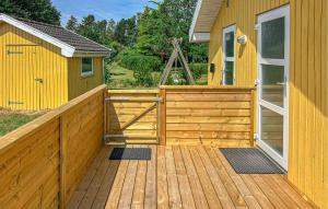 a large wooden deck with a yellow house at Holiday Home Laxtonvej Humble in Humble