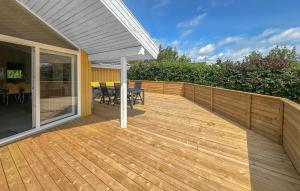 a wooden deck with a table and chairs on it at Holiday Home Laxtonvej Humble in Humble
