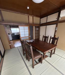 a dining room with a wooden table and chairs at 灯ゲストハウス石巻 in Ishinomaki