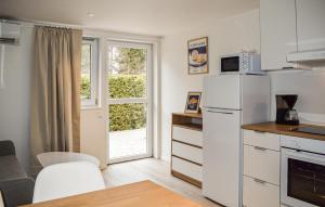 a kitchen with a white refrigerator and a window at Beautiful Home In Ystad in Ystad