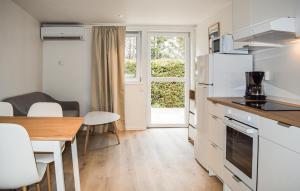 a kitchen and dining room with a table and a refrigerator at Beautiful Home In Ystad in Ystad