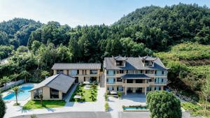 an aerial view of a villa with a mountain at Chyanmu Hidden Village Retreat Near The Grand Canyon of Zhangjiajie and Yellow Dragon Cave With Local Culture Village Life Breakfast Quiet Wellness Escape for Urban Travelers Seeking Privacy and Peace in Zhangjiajie