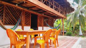 a wooden table with yellow chairs at Villa Neluc in San Bernardo del Viento