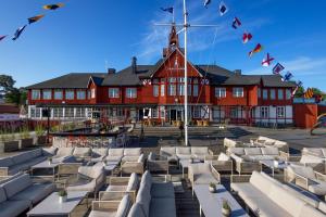 a large red building with white chairs in front of a building at Sandhamn Seglarhotell in Sandhamn