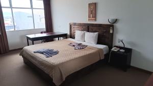 a hotel room with a bed with two towels on it at Hotel Maragato in San José