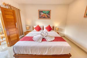 a bedroom with a bed with a bow on it at Gati Cottage in Nusa Penida