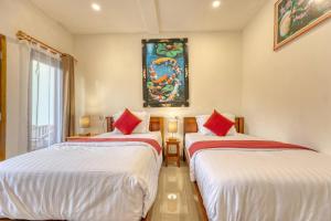 a room with two beds and a painting on the wall at Gati Cottage in Nusa Penida