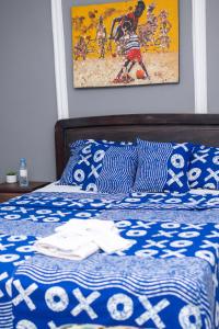 a bed with a blue and white comforter on it at Villa Miradie in Grand-Bassam +12 photos