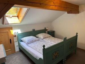 a bedroom with a green bed with two pillows at Ferienwohnung Hoisenlehen in Marktschellenberg