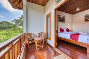 a bedroom with a bed and a balcony with a table and chairs at Gati Cottage in Nusa Penida